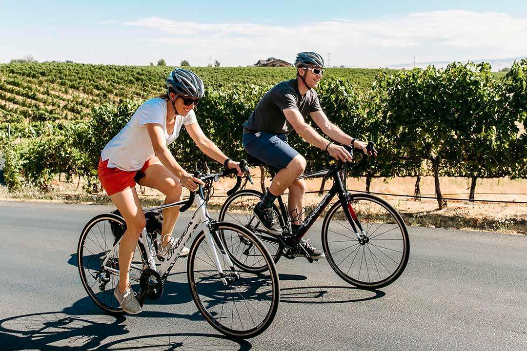couple biking through vineyard