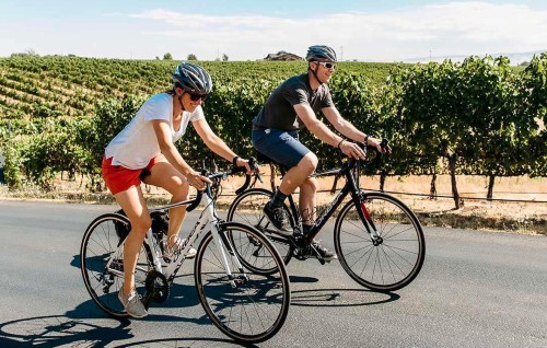 Couple Biking Through Vineyards